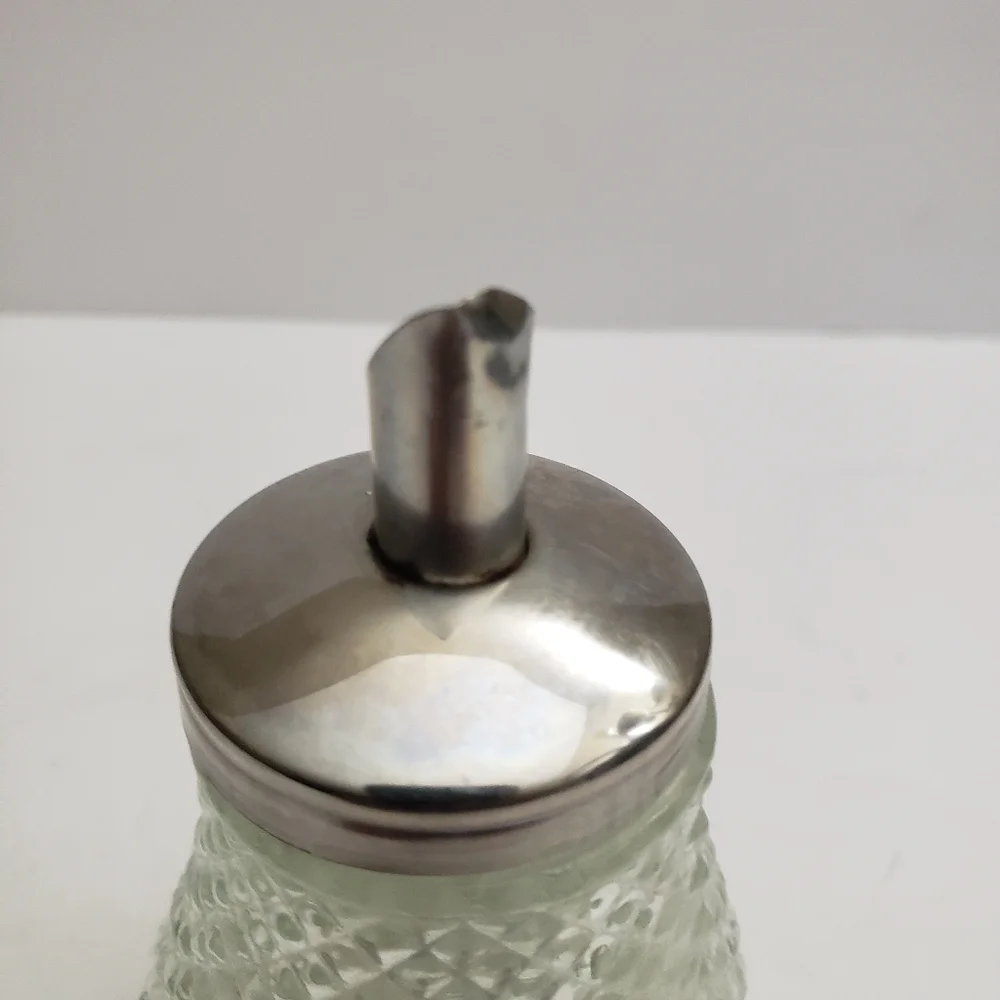 Glass sugar dispenser with a metal lid and spout. 206